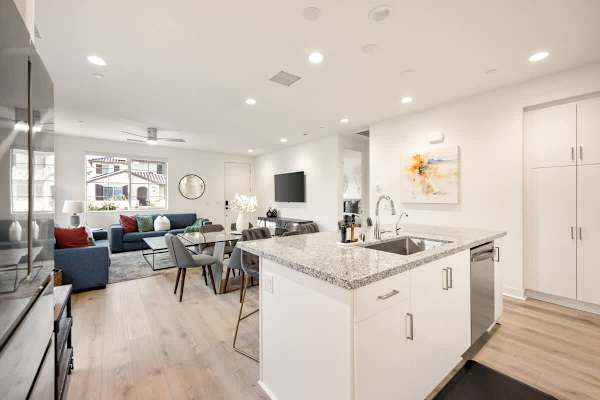 Modern kitchen with granite counters and stainless appliances opens to the dining and living areas.