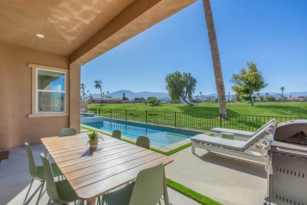 Expansive outdoor living with a sparkling pool overlooking the lush fairways.