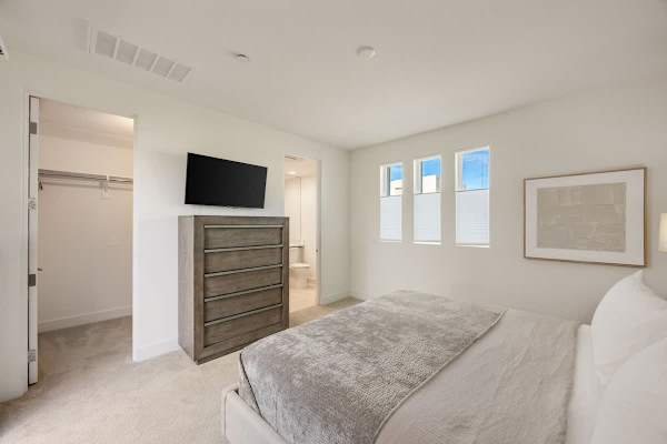 A peaceful bedroom with TV and storage space, perfect for guests who want their own area.