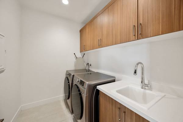 Full-size washer and dryer with plenty of counter space for folding and storage above.