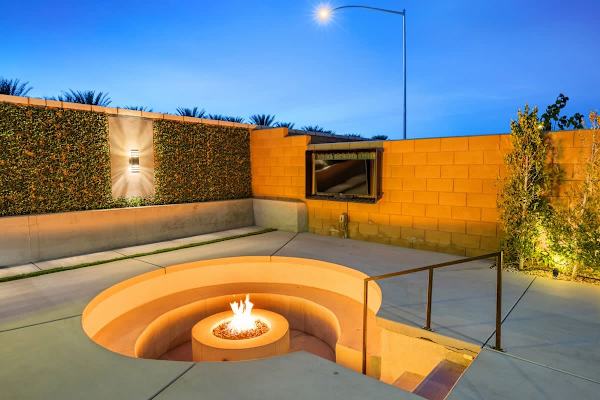 Lit pool, glowing fire pit & mountain silhouettes.