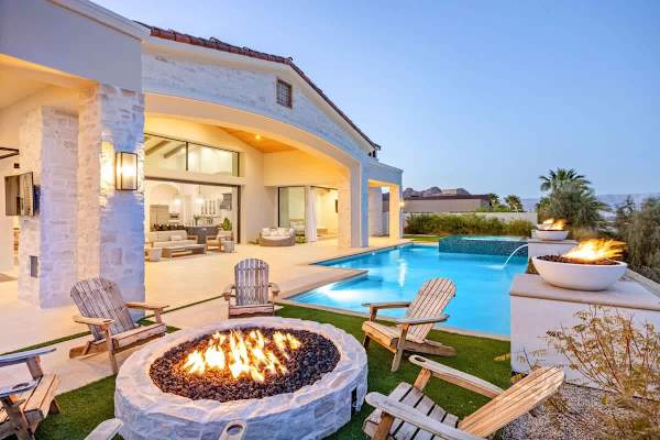 Your desert retreat glows at twilight with a sparkling pool and crackling fire pit.