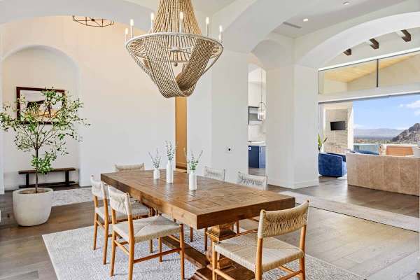 Elegant dining table for ten sits beneath a statement chandelier with patio access.