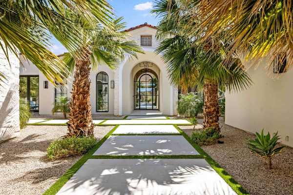 Palm-lined walkway welcomes you to this stunning Spanish-style desert estate.