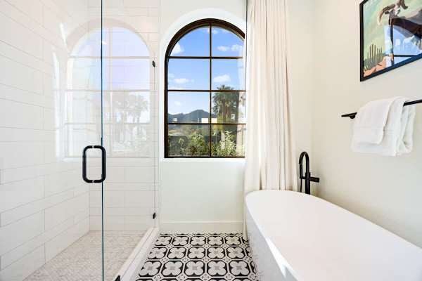 Bright white shower with arched window and classic tile details.