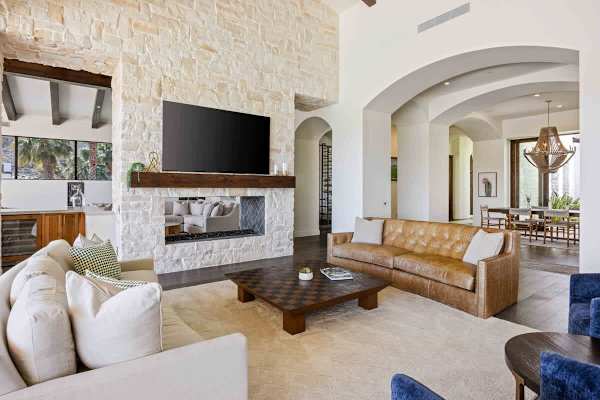Stone fireplace and archways give this living space classic Mediterranean charm.