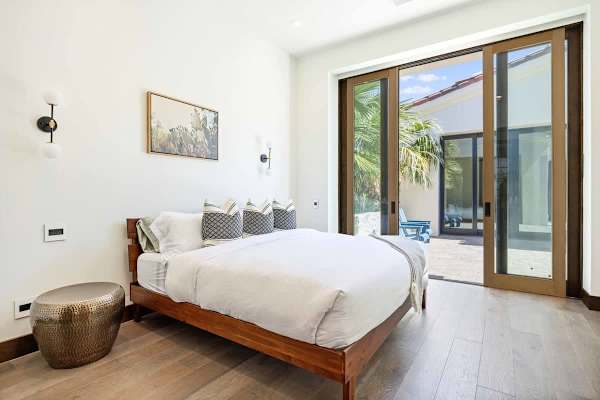 Casita bedroom with wood-framed glass doors opening to the pool area.