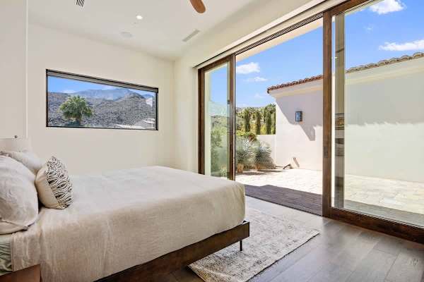 Serene guest room opens to a private courtyard with mountain views.