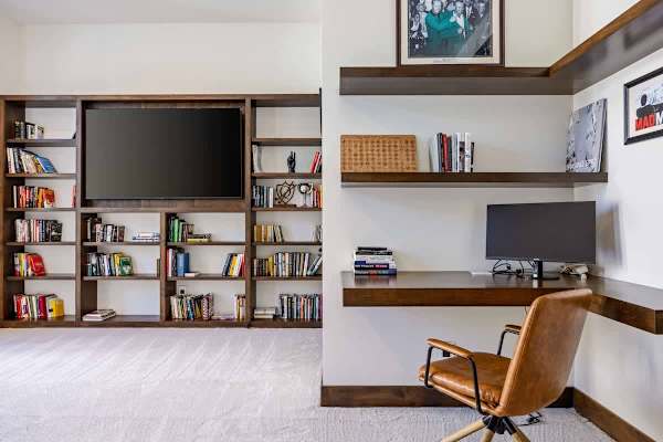 Quiet reading nook with built-in bookshelves and a leather accent chair.