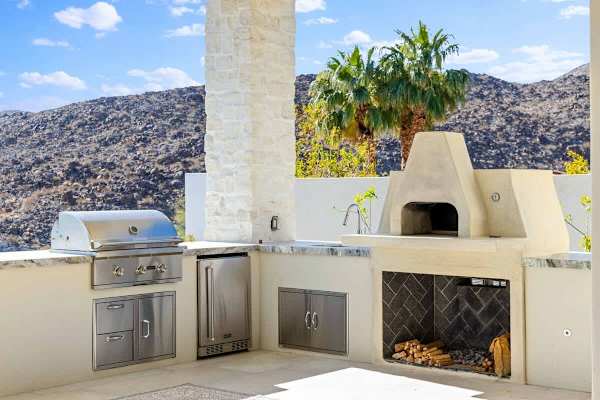 Built-in grill and wood-fired pizza oven make outdoor feasts effortless.