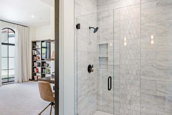 Marble walk-in shower with built-in bench and glass enclosure.