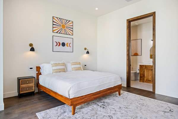 Bright guest bedroom with mid-century furniture and private bathroom access.