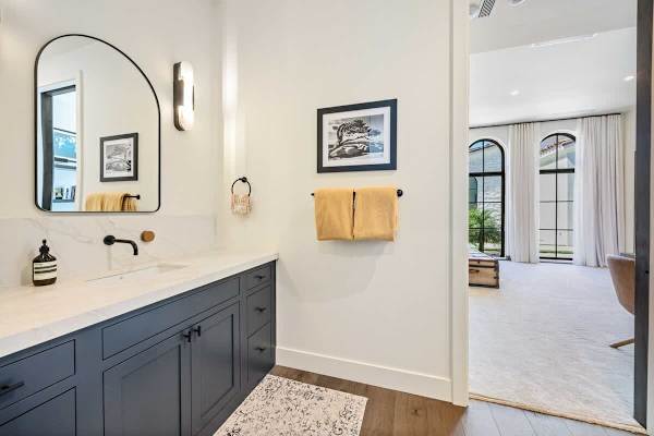 Navy vanity and arched black-framed windows add character to this guest bath.