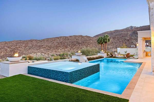 Elevated spa spills into the main pool creating a stunning waterfall effect.