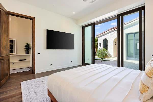 Wake up to pool and mountain views through floor-to-ceiling glass doors.