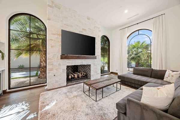 Private casita living room with stone fireplace and arched courtyard views.