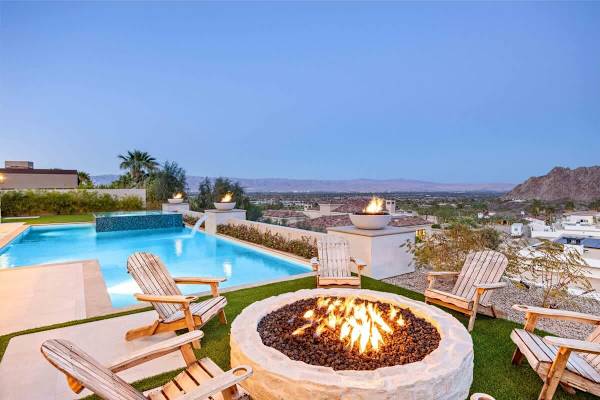 The property has it all: stunning views, cozy fire pit, and plenty of living spaces both indoors and outdoors.