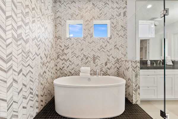 Master bathroom featuring a sleek design and a tub.