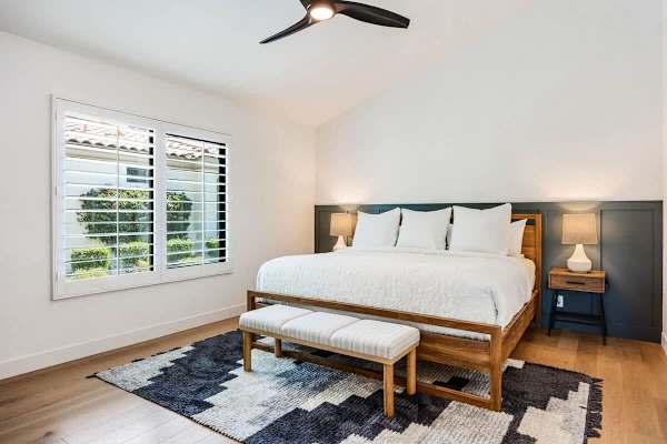 Third bedroom with wood platform bed and shutters.