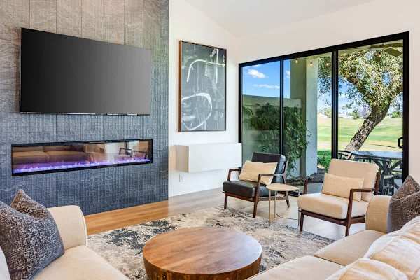 Modern fireplace and floor-to-ceiling golf course windows.