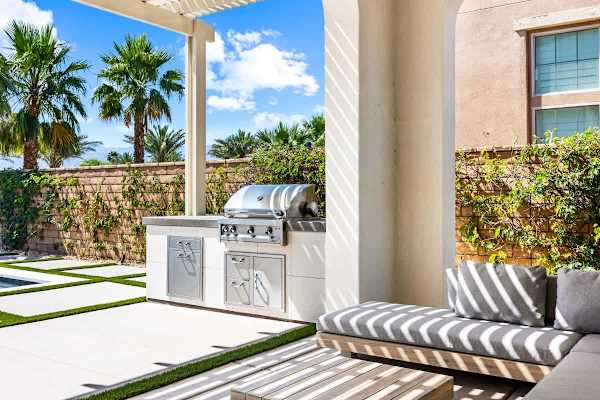 Covered patio with outdoor lounge seating creates a shaded retreat..