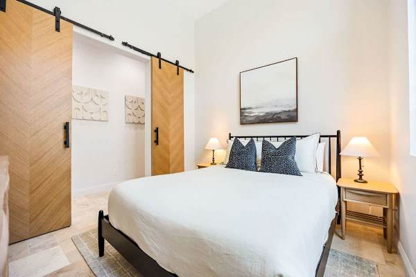 Third bedroom with queen bed and barn door closet offers a quiet retreat for additional guests.