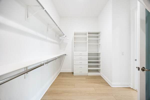 Spacious walk-in closet with custom shelving keeps everything organized.