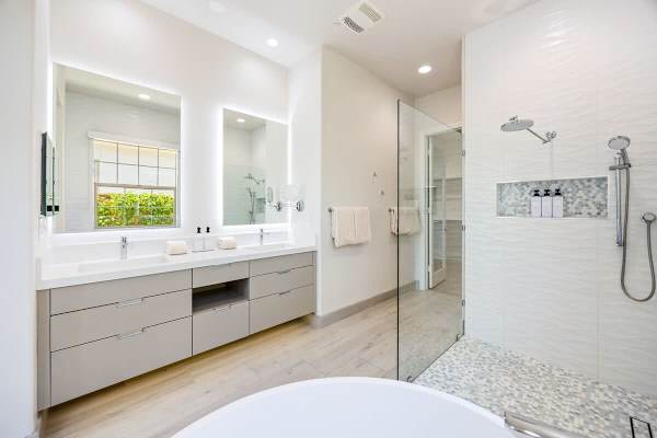 Luxurious primary bath features freestanding tub and rainfall shower.