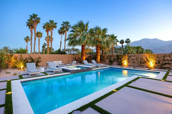 Your desert oasis comes alive at night with ambient lighting and palm silhouettes.