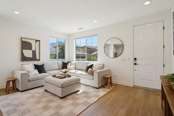 Modern living room with sectional sofa and round mirror creates a welcoming space to relax after desert adventures.