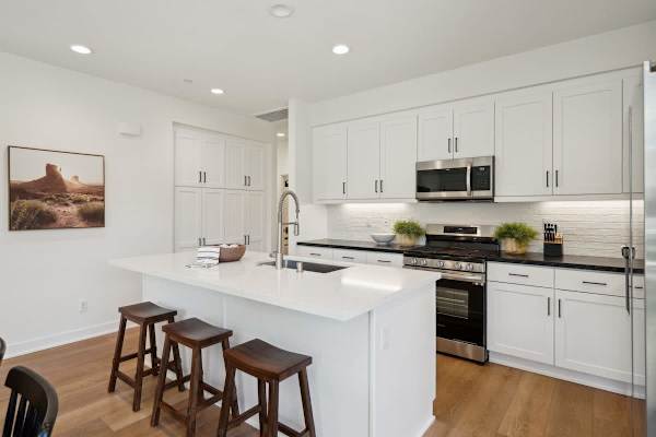 White kitchen with island seating and stainless appliances has everything you need to prepare meals during your stay.