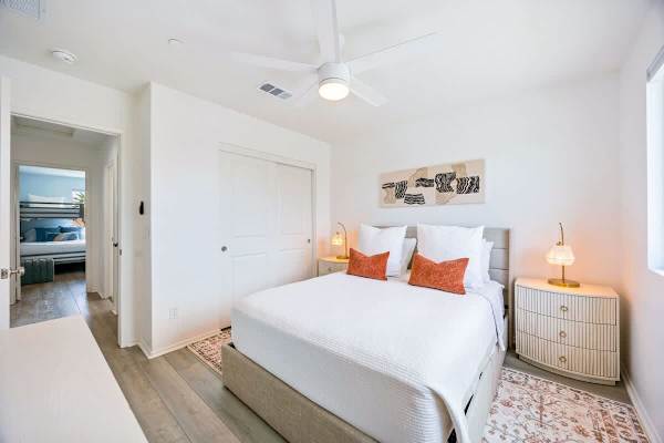 Fifth bedroom with queen bed and rattan nightstands.