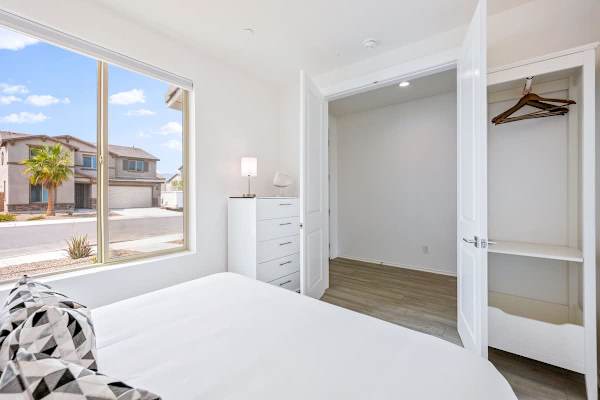 Sixth bedroom with queen bed and large windows provides natural light and closet space for a comfortable stay here.