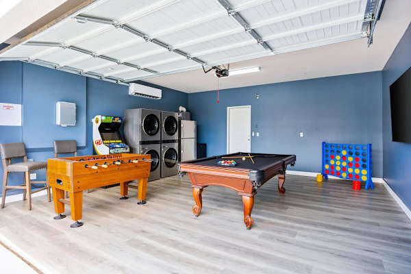 Converted garage game room with pool table, foosball, and arcade games.