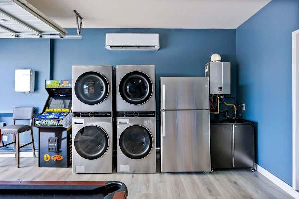 Garage laundry room features two washers and two dryers.