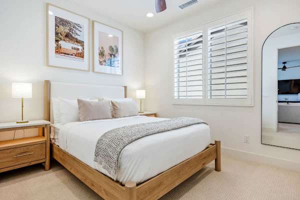 The second bedroom has a comfortable queen bed and natural light from the windows.