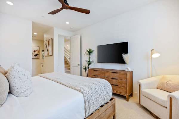 The primary suite features a king bed, wall-mounted TV, and its own bathroom entrance.