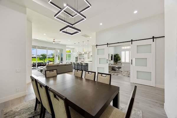 The dining area features a stunning pendant chandelier and seating for eight!
