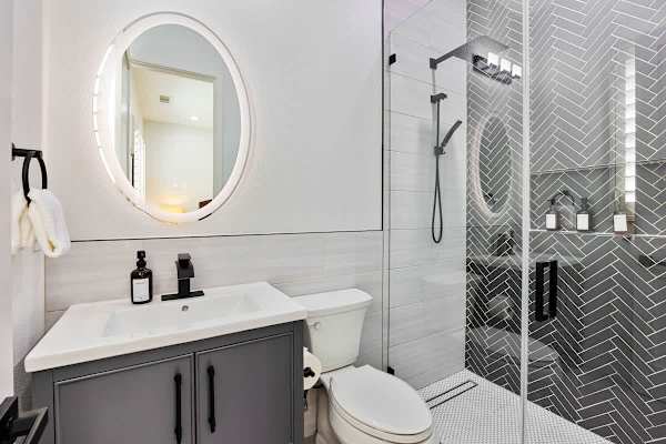 Modern guest bathroom with herringbone tile and a refreshing walk-in shower.