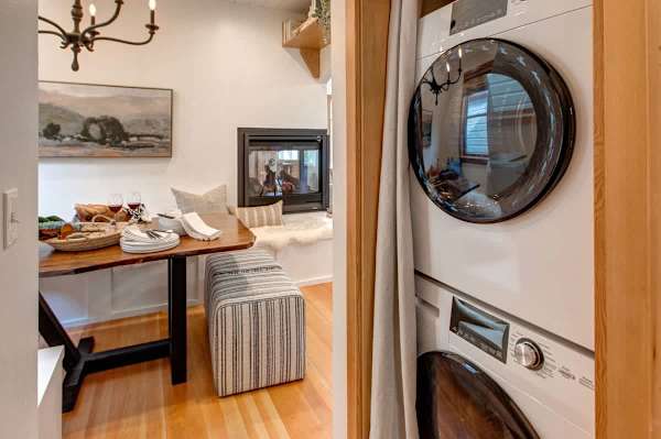 Stacked laundry and dryer next to dining area.