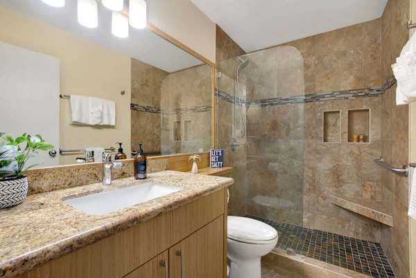 The second bathroom is equipped with a walk-in shower and a vanity with a cabinet.