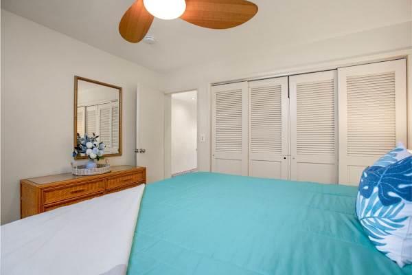 Bedroom includes dresser, closet, and ceiling fan