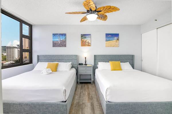 2 Queen-size beds in the living room with a ceiling fan