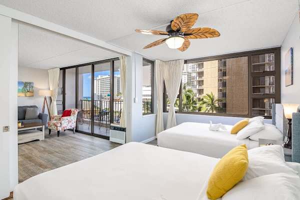 2 Queen-size beds in the living room with a ceiling fan