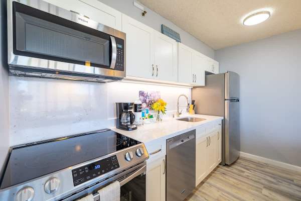 Fully equipped kitchen includes dishwasher, microwave, fridge, cook top stove, and oven
