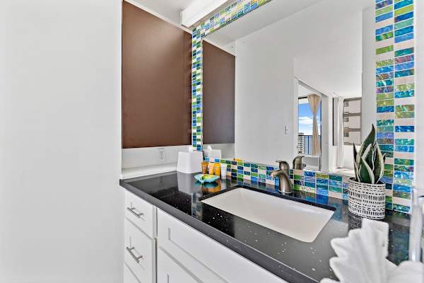 The bathroom has a vanity with cabinet