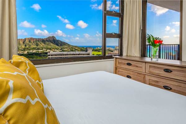 Bedroom with mountain and ocean views through large windows