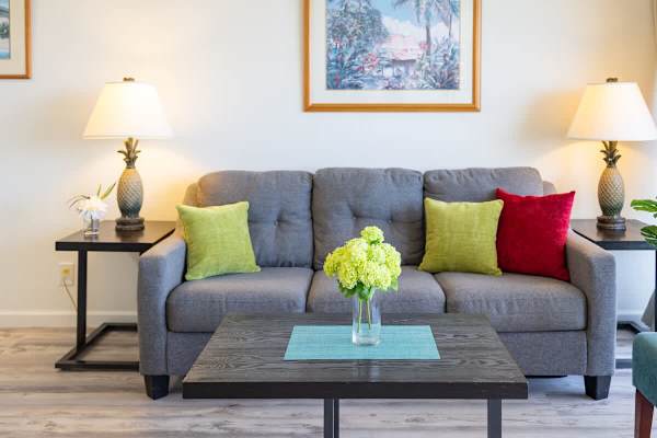 Modern living room with a gray sofa accented by colorful pillows and soft lighting.
