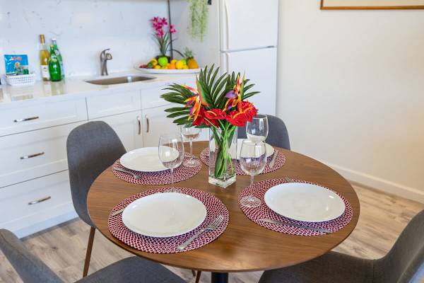 Dining table set for four in a modern kitchen with fresh floral centerpiece.