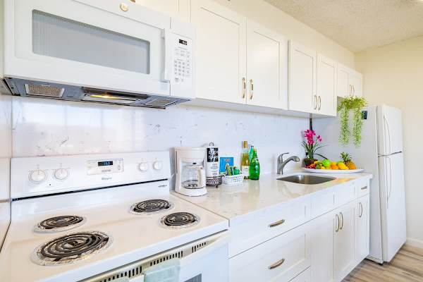 Bright kitchen with white cabinetry and essential appliances for convenient cooking.
